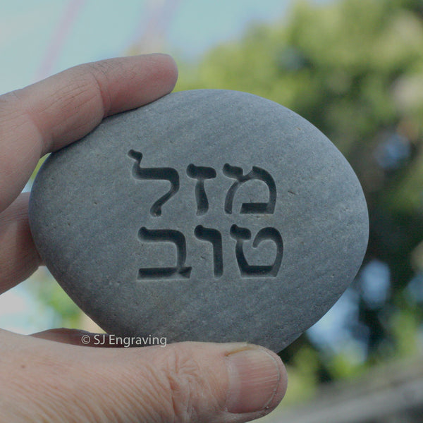 Engraved Hebrew Mazel tov on beach pebble